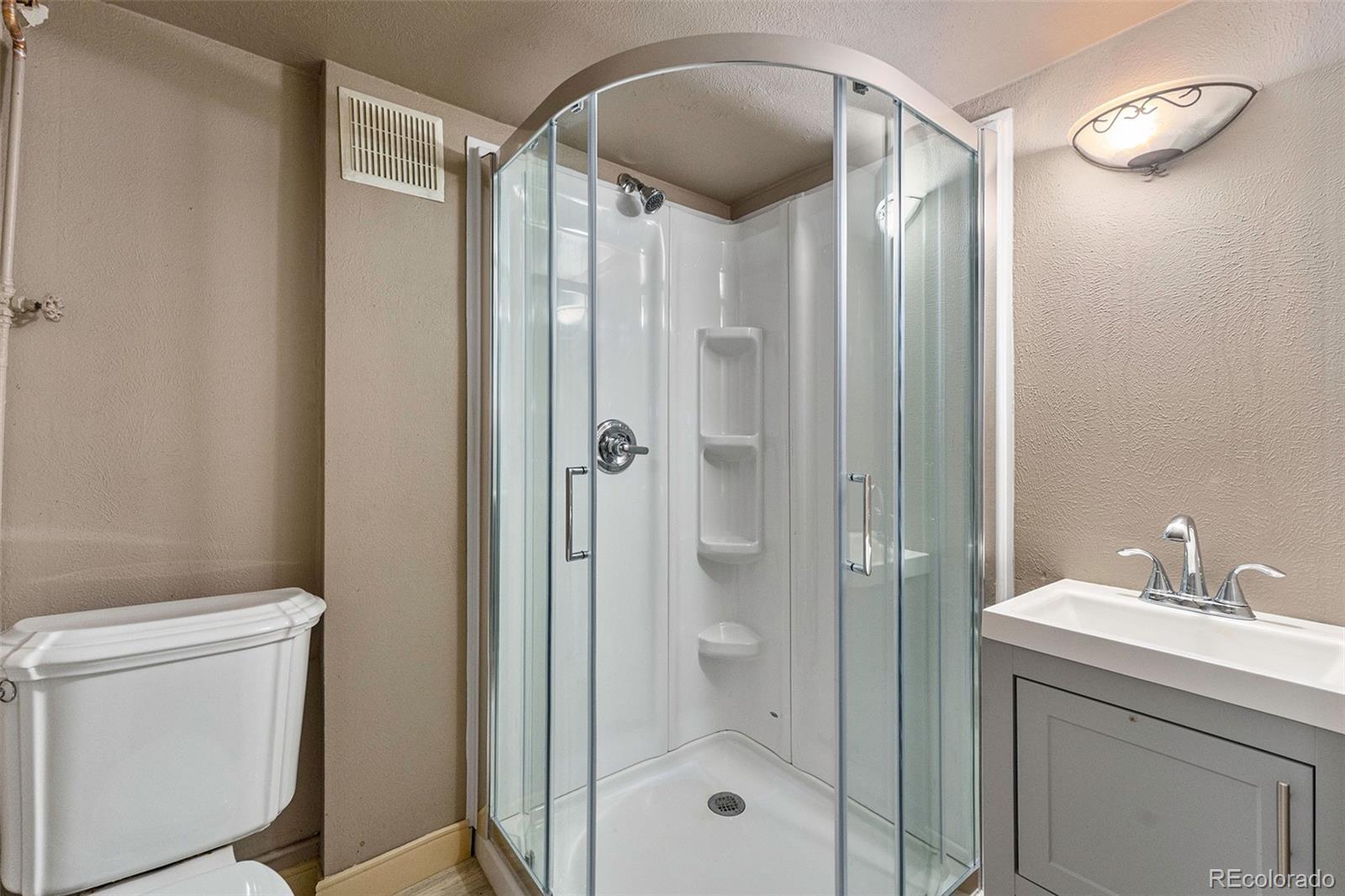 1314 Vine Street Denver, CO 80206 - Photo 23 of 34 a bathroom with a shower a toilet and a sink