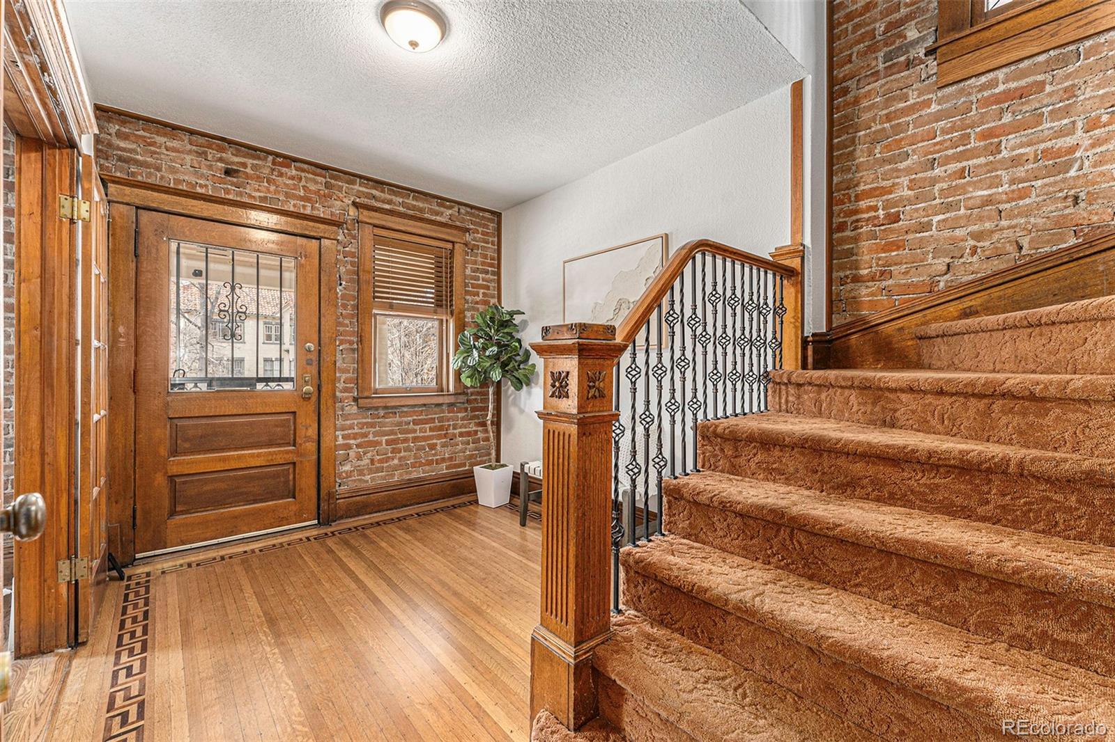 1314 Vine Street Denver, CO 80206 - Photo 4 of 34 a view of front door with wooden floor and stairs