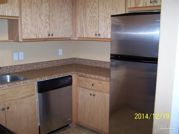 a kitchen with granite countertop cabinets and refrigerator