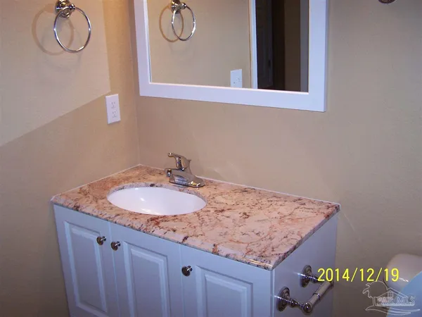 a bathroom with a granite countertop sink and a mirror
