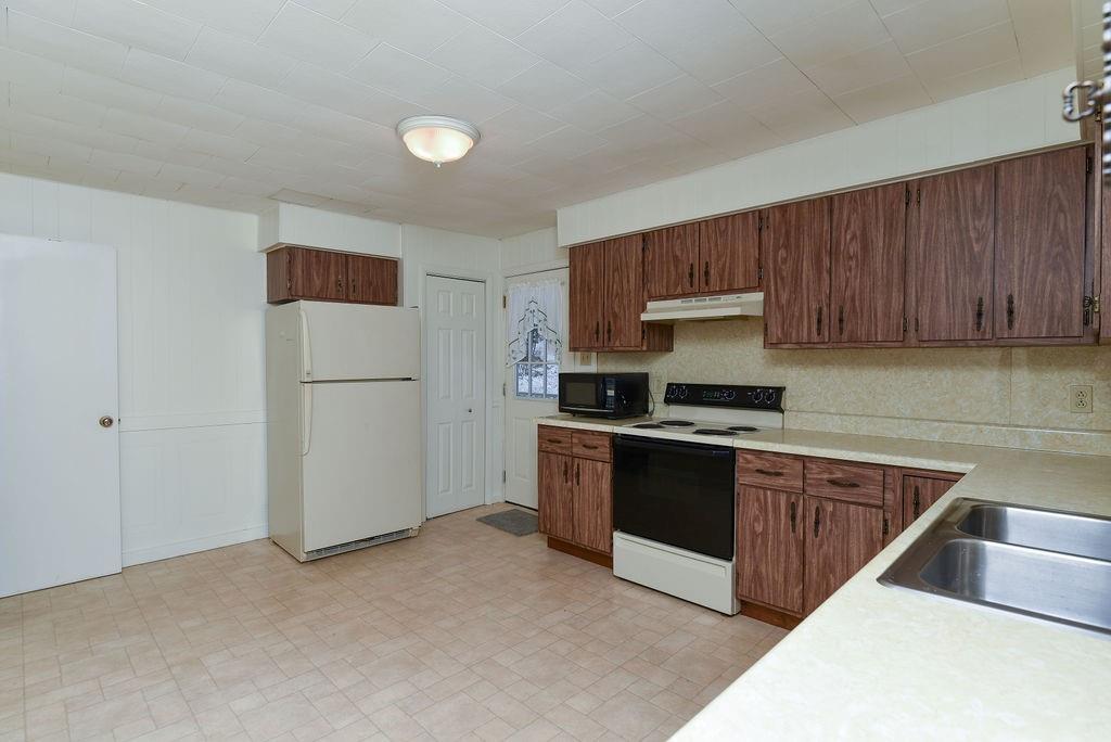 110 Gill Drive Beaver Falls, PA 15010 - Photo 19 of 25 a kitchen with stainless steel appliances granite countertop a stove a sink and a refrigerator
