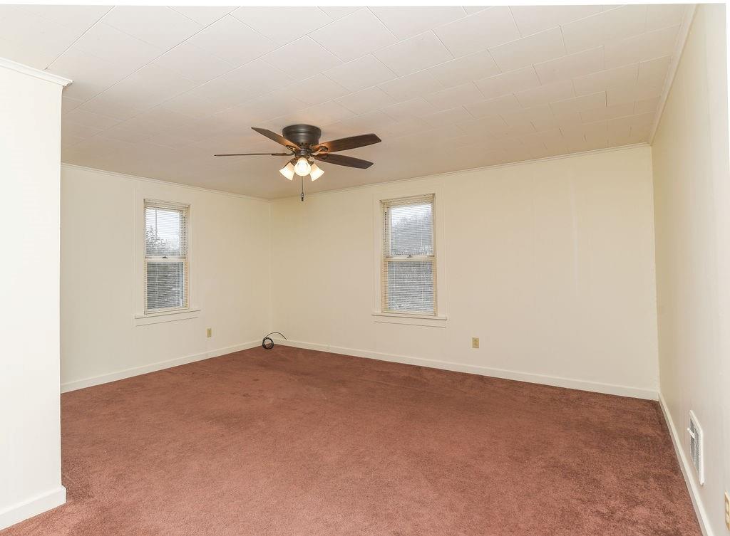 110 Gill Drive Beaver Falls, PA 15010 - Photo 20 of 25 an empty room with a chandelier fan and windows