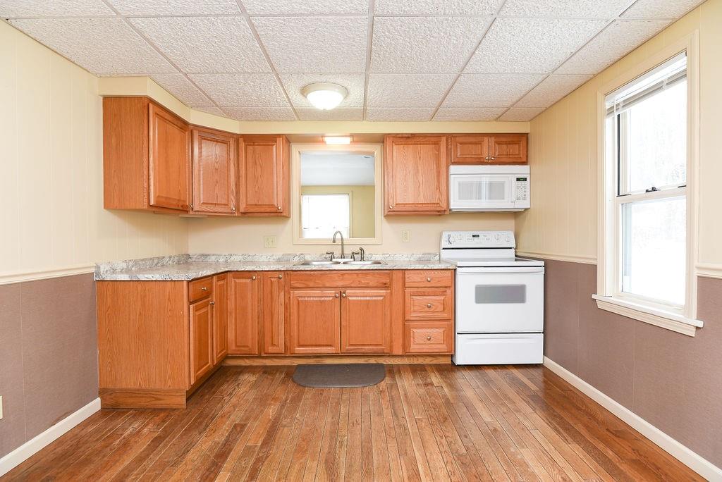 110 Gill Drive Beaver Falls, PA 15010 - Photo 9 of 25 a kitchen with granite countertop wooden floors and white appliances
