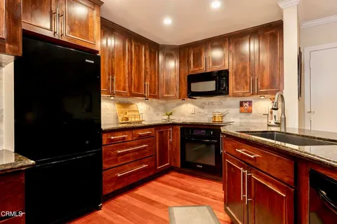 a kitchen with granite countertop stainless steel appliances and cabinets