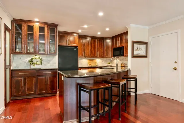 a kitchen with stainless steel appliances granite countertop wooden cabinets and counter top space