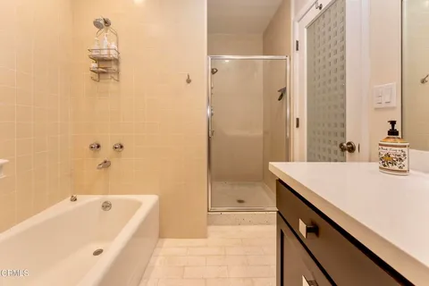 a bathroom with a tub sink and mirror