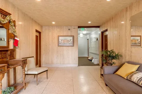 a view of a hallway with furniture and a potted plant