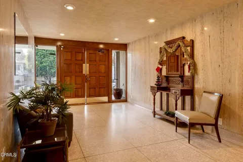 a view of a hallway with furniture and a large window