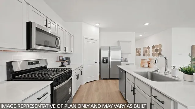 a kitchen with stainless steel appliances kitchen island granite countertop a sink stove and refrigerator