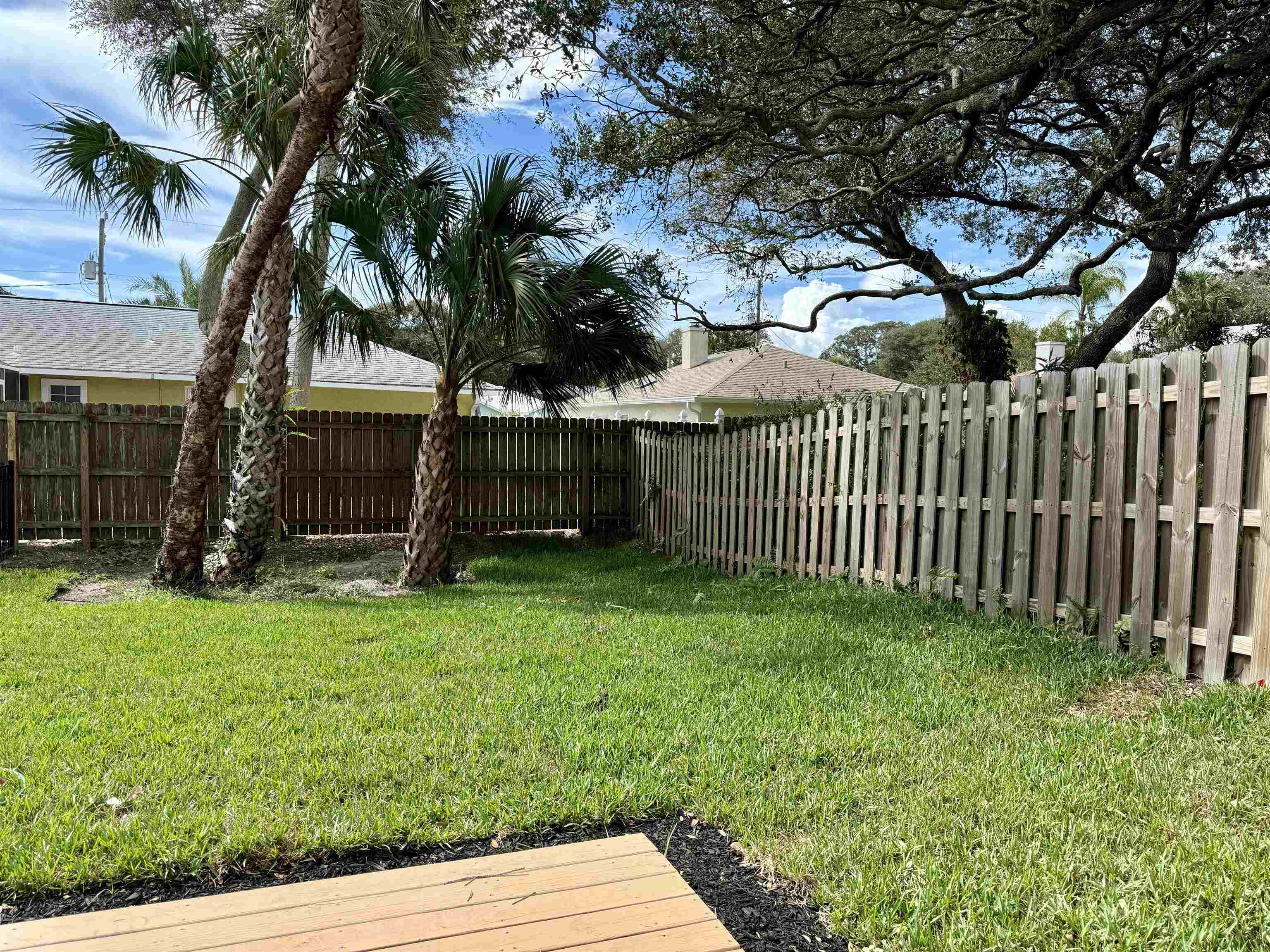 205 6th Street St. Augustine, FL 32080 - Photo 16 of 18 a view of backyard with wooden fence and a large tree