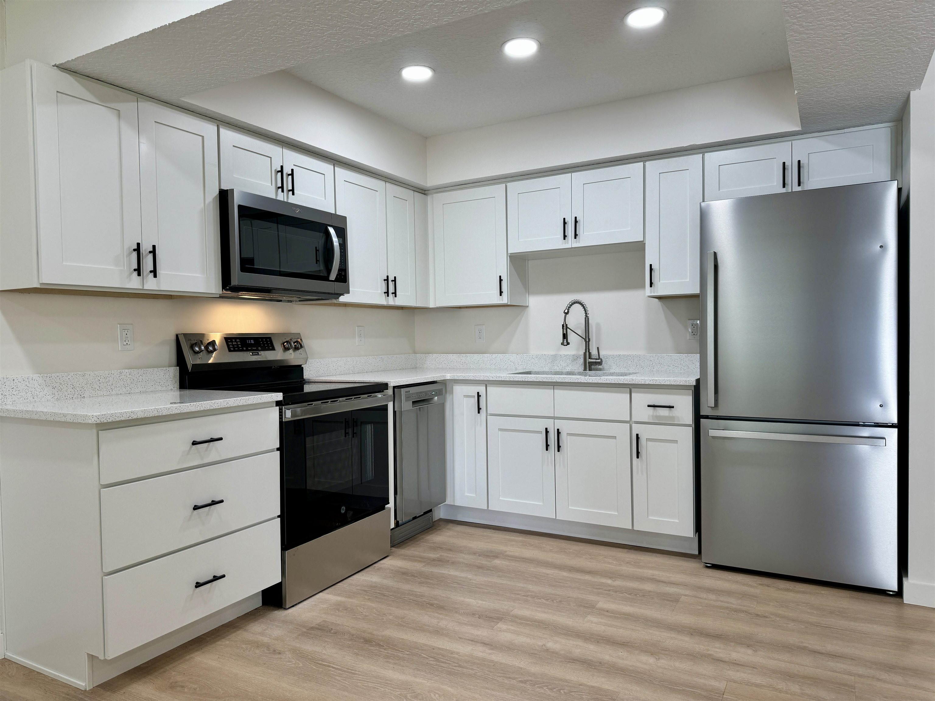 205 6th Street St. Augustine, FL 32080 - Photo 6 of 18 a kitchen with a refrigerator stove and white cabinets