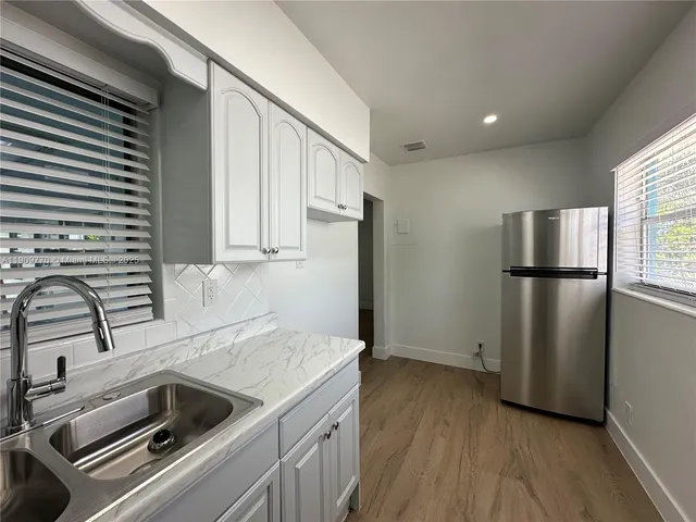 a kitchen with a refrigerator and a sink