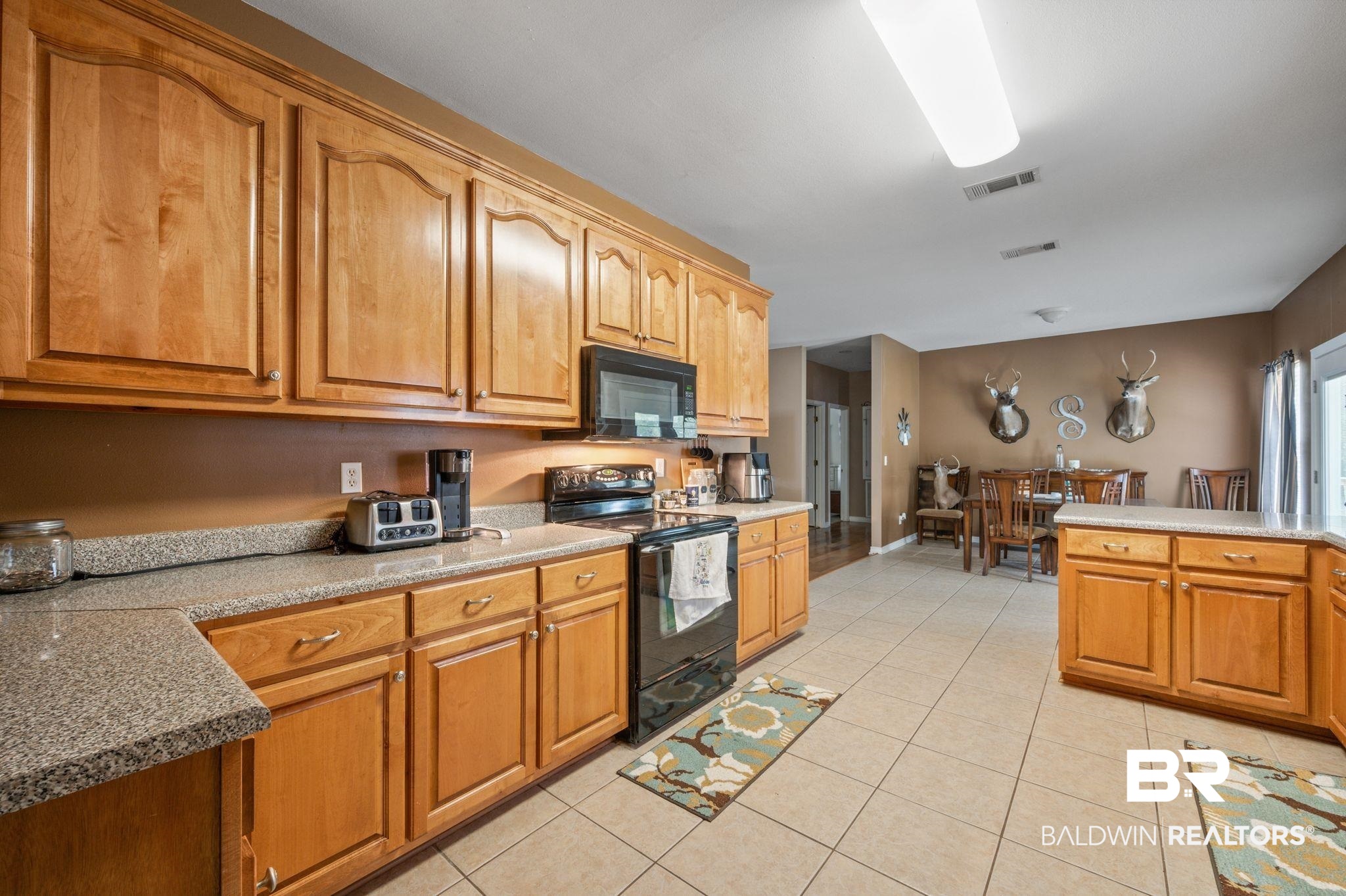 9539 Lakeview Road Bay Minette, AL 36507 - Photo 10 of 45 Kitchen with kitchen peninsula, light tile patterned floors, and black appliances