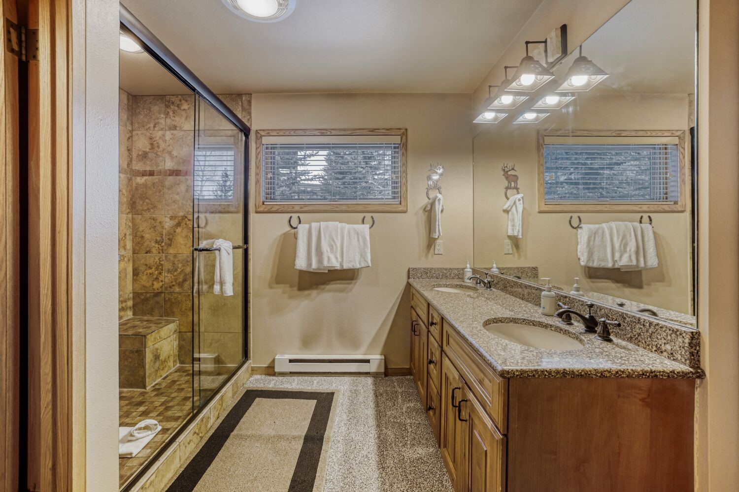 22804 Highway 6, Unit 108 Keystone, CO 80435 - Photo 11 of 28 Full bathroom with double vanity, a shower stall, and a baseboard radiator