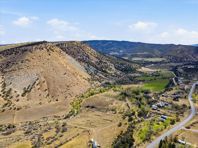 811 East Canyon Road Mayfield, UT 84643 - Photo 49 of 57 Expansive rural landscape featuring a winding road, scattered residential structures, and a prominent mountainous backdrop