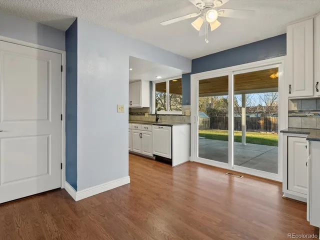 a open kitchen with granite countertop a stove top oven a sink and a wooden floor