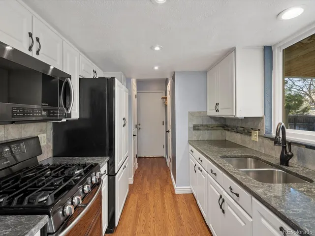 a kitchen with stainless steel appliances granite countertop a sink stove and refrigerator