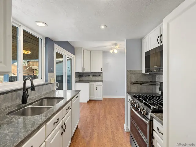 a kitchen with stainless steel appliances granite countertop a sink stove and refrigerator