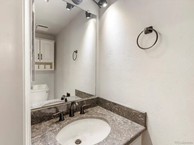 a bathroom with a granite countertop sink and a mirror
