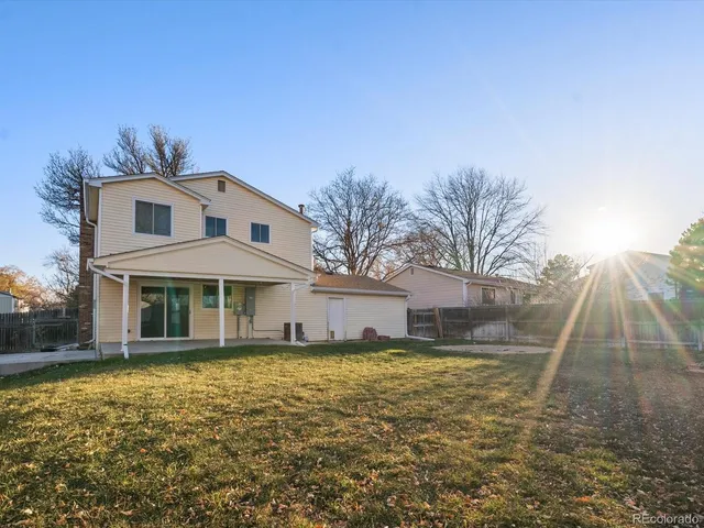a front view of a house with a yard and potted plants