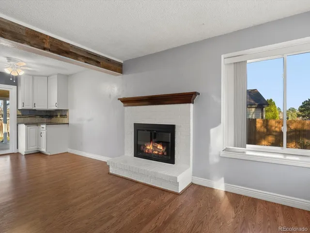 a living room with a fireplace and wooden floor