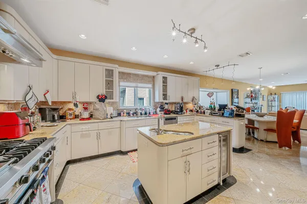 a kitchen with white cabinets appliances and a sink