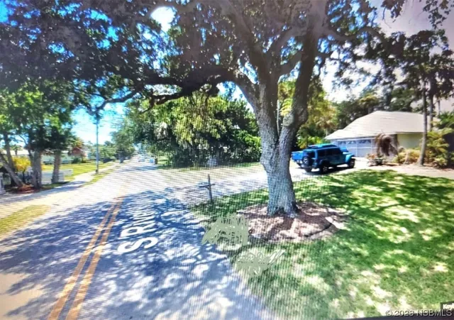 a view of backyard with a garden and trees