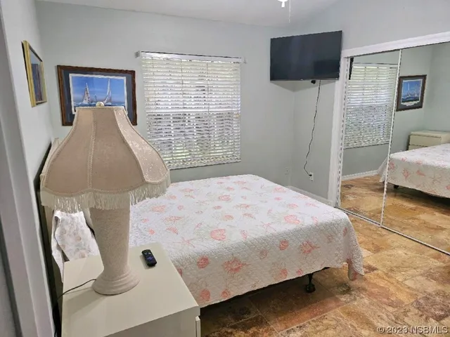 a bedroom with a bed and a flat tv screen