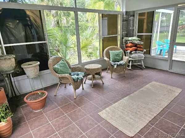 a living room with patio furniture and a floor to ceiling window