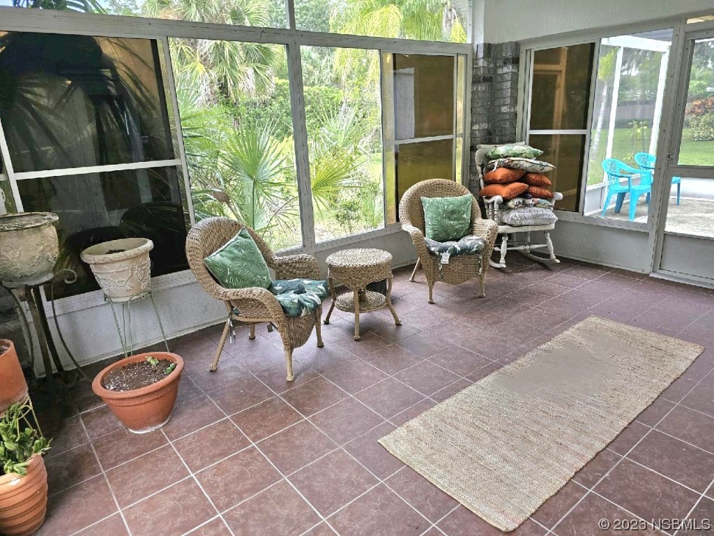 1308 South Riverside Drive Edgewater, FL 32132 - Photo 5 of 16 a living room with patio furniture and a floor to ceiling window