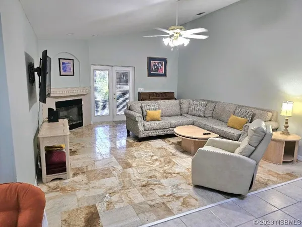 a living room with furniture a fireplace and a chandelier