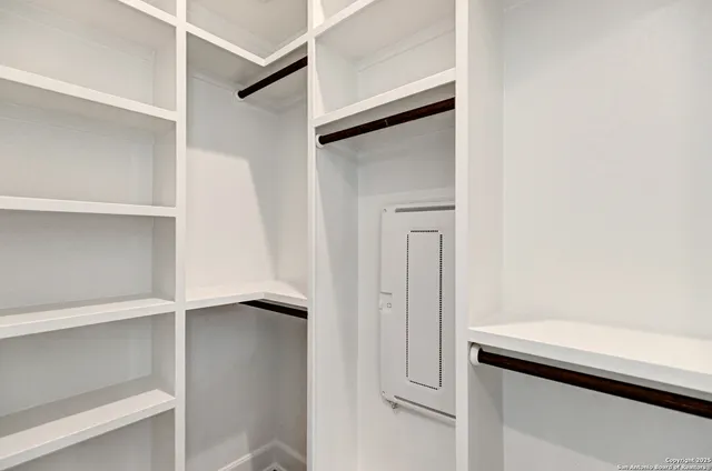 a view of walk in closet with empty racks