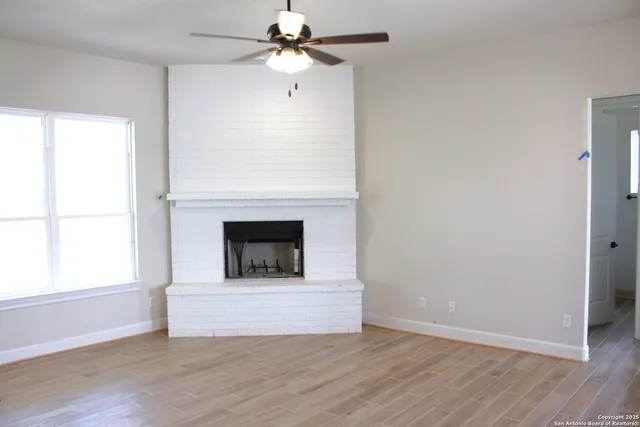a view of a livingroom with a fireplace and a ceiling fan