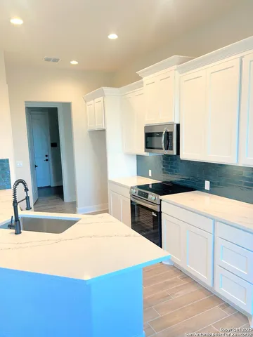 a kitchen with stainless steel appliances kitchen island a stove a sink and a refrigerator