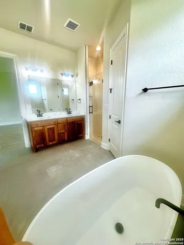 a bathroom with a tub a sink and a mirror
