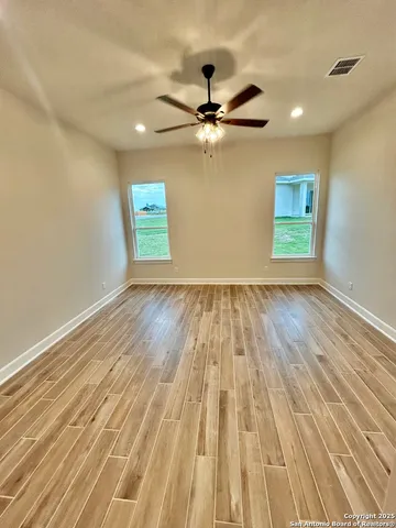 a view of empty room with wooden floor