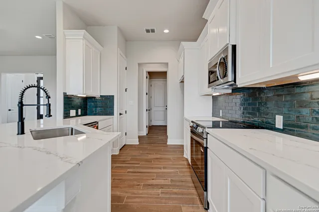 a kitchen with a sink and a stove top oven