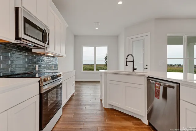 a kitchen with stainless steel appliances granite countertop a stove microwave and sink