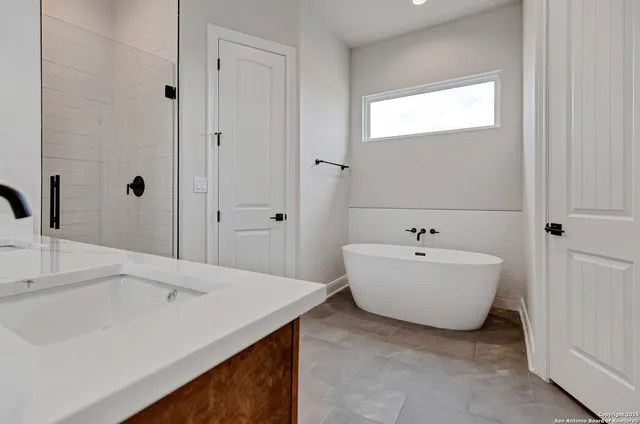 a spacious bathroom with a bathtub sink and mirror