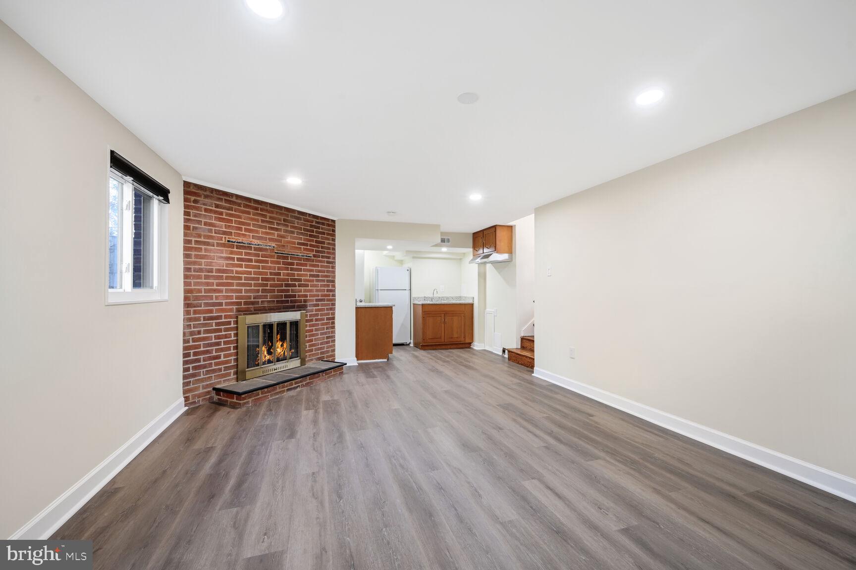 10117 Renfrew Road Silver Spring, MD 20901 - Photo 12 of 15 an empty room with wooden floor and fireplace