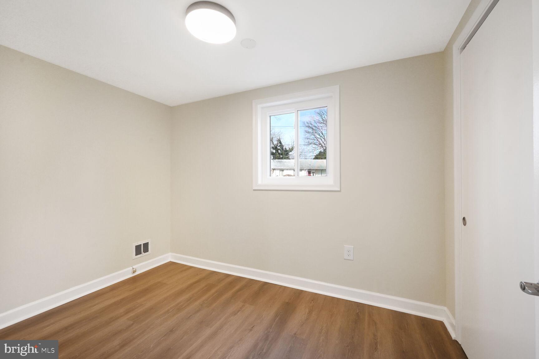 10117 Renfrew Road Silver Spring, MD 20901 - Photo 13 of 15 an empty room with wooden floor and windows