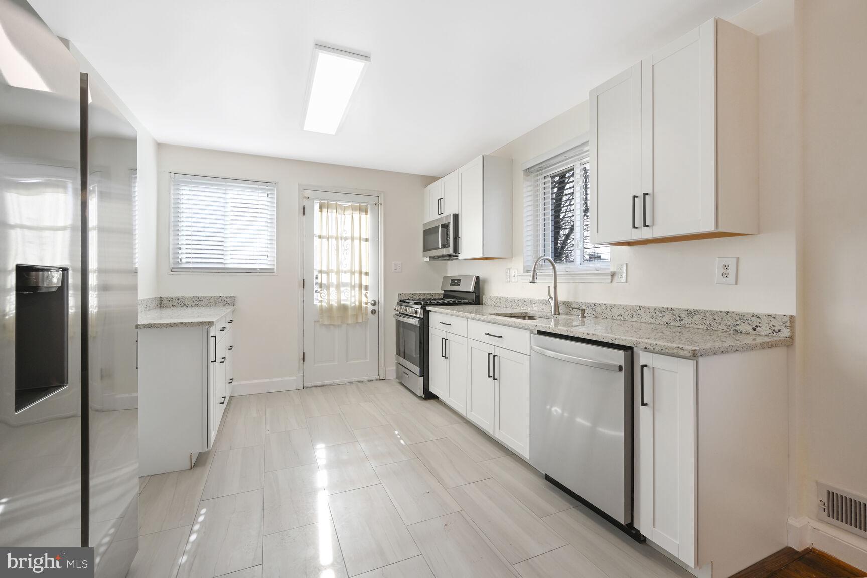 10117 Renfrew Road Silver Spring, MD 20901 - Photo 4 of 15 a kitchen with granite countertop white cabinets and white appliances