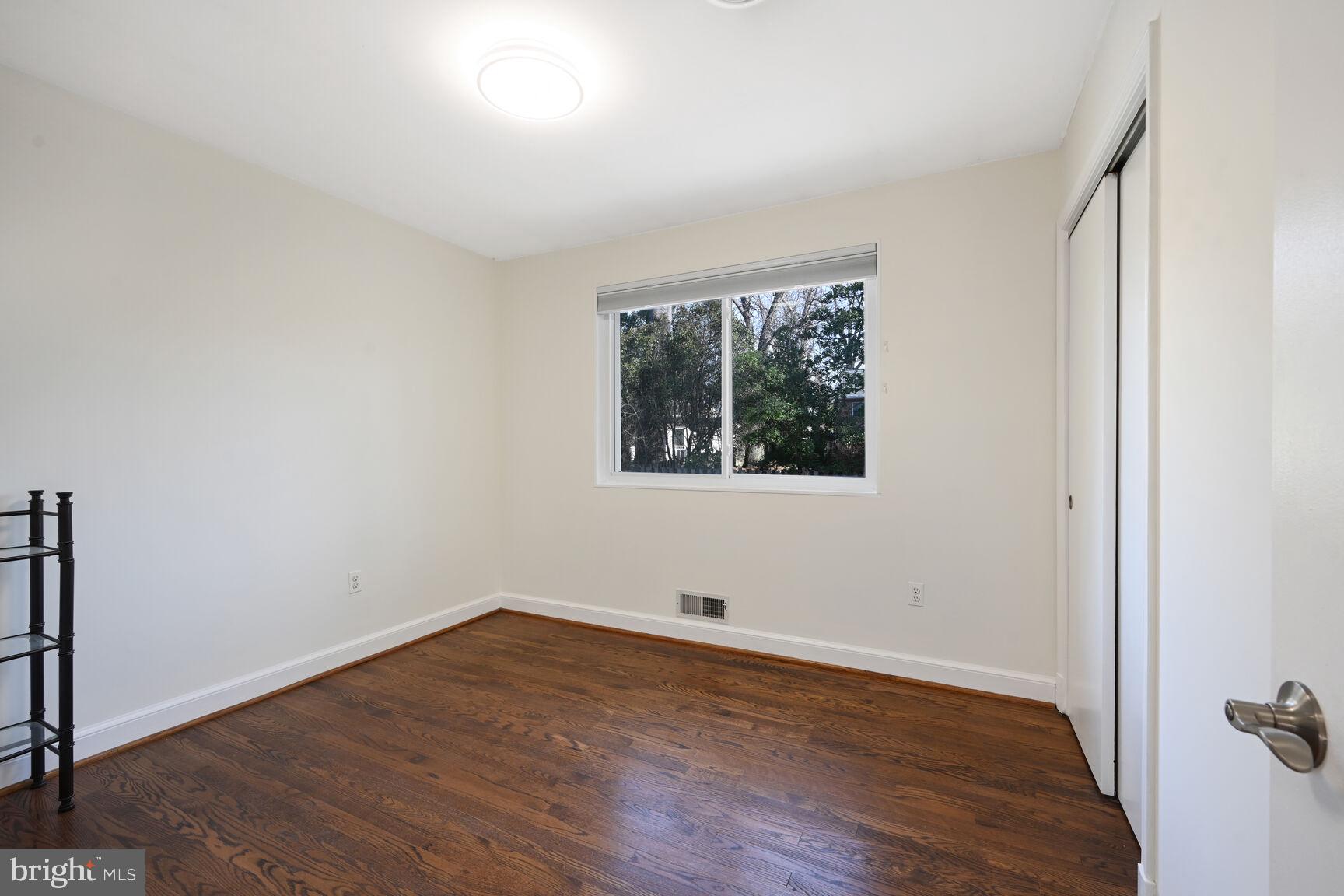 10117 Renfrew Road Silver Spring, MD 20901 - Photo 7 of 15 an empty room with wooden floor and windows