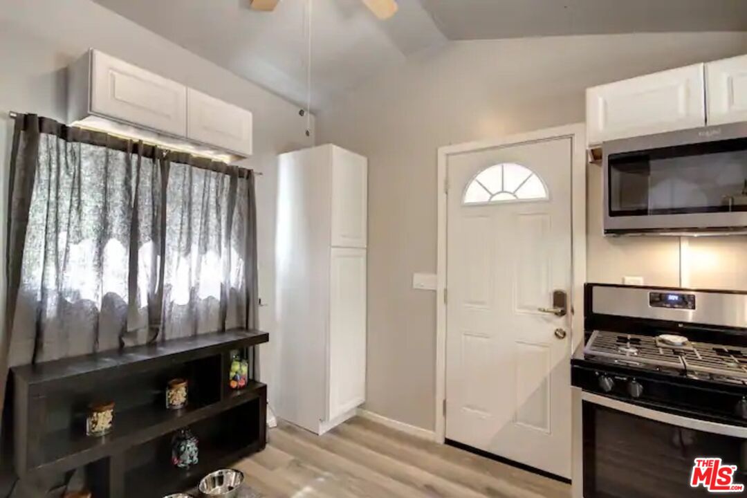39219 Cedar Dell Road Fawnskin, CA 92333 - Photo 4 of 23 a kitchen with granite countertop a refrigerator and a stove top oven