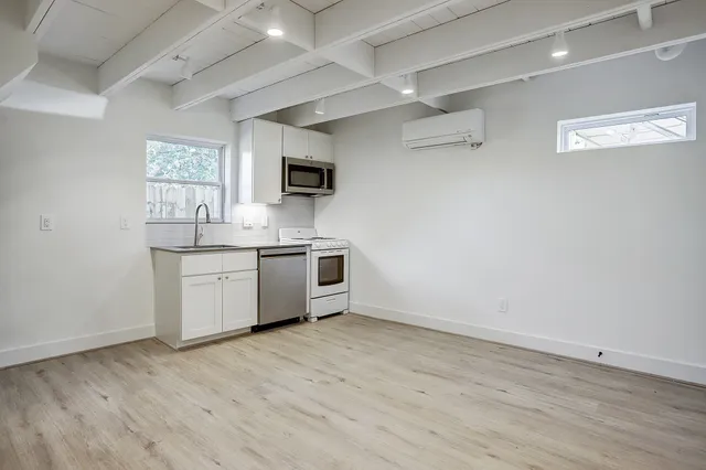 a kitchen with a sink cabinets and wooden floor