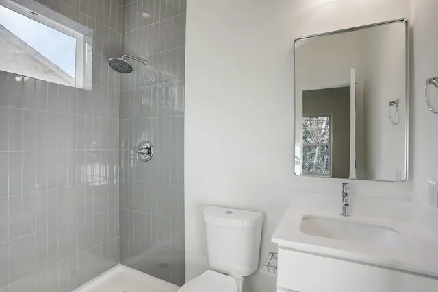 a bathroom with a toilet sink shower and mirror