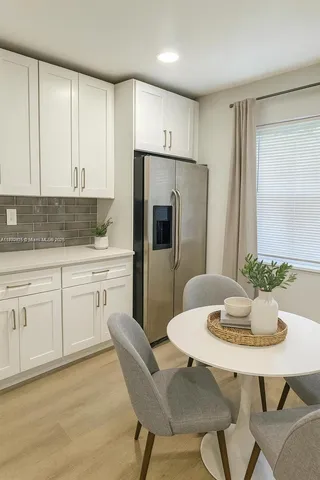 a kitchen with stainless steel appliances a dining table chairs and granite counter tops