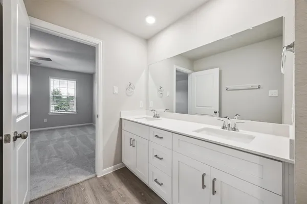 a spacious bathroom with a double vanity sink and mirror