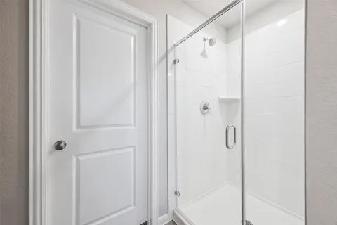 a bathroom with a shower and a glass door