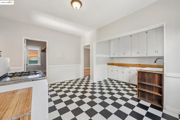 a kitchen with a checkered floor and white cabinets